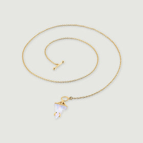 A yellow gold vermeil chain curves around a pointed moonstone pendant and a separate rounded toggle bar on a light gray surface.