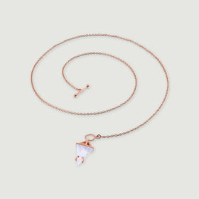 A rose gold vermeil necklace rests in an open coil, showing its linked chain and pale triangular moonstone on gray.