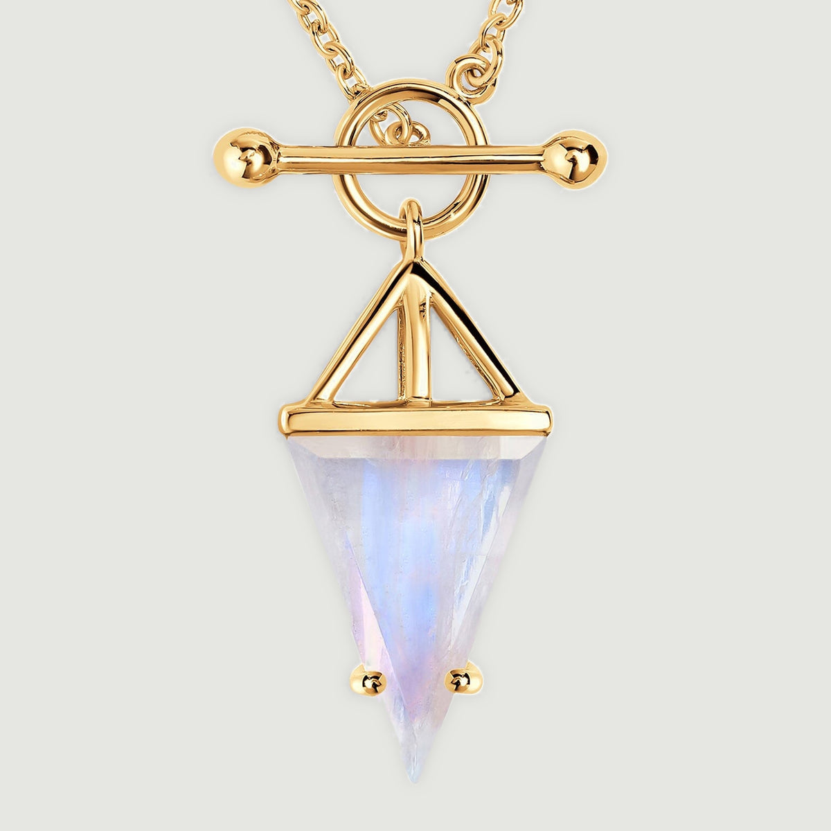 The yellow gold vermeil pendant has an open triangular mount above a pale moonstone with a soft blue reflection.