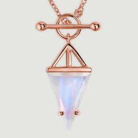 A rose gold vermeil toggle and open triangular setting frame a pointed moonstone in this close detail.