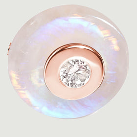 A round moonstone disc surrounds a rose gold vermeil center bezel and a small faceted clear gemstone.