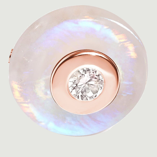 A round moonstone disc surrounds a rose gold vermeil center bezel and a small faceted clear gemstone.