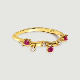 Three pink-red stones and small clear accents follow the wavy yellow gold vermeil band.