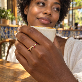 A yellow gold vermeil ring is visible on a hand holding a ceramic coffee cup.