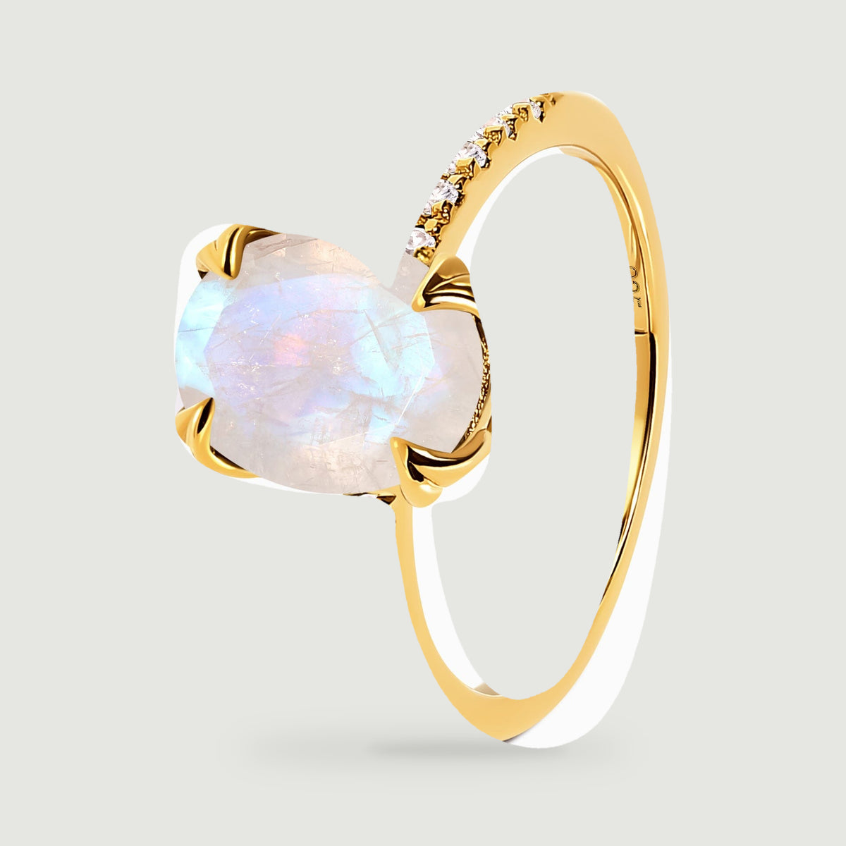 The yellow gold vermeil ring stands at an angle with a blue-flashing moonstone and polished inner band.