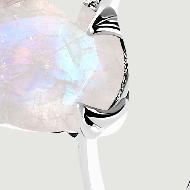 A close angled view reveals the moonstone edge and individual clear stones set into the silver shoulder.