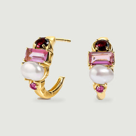 A yellow gold-tone earring pair shows its open hoop curves, white pearls and pink gemstone settings.