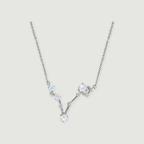 The sterling silver necklace has a V-shaped arrangement of four round moonstones and small clear accents on a light gray background.