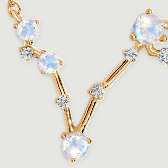 A close view shows pale iridescent moonstones held by yellow gold prongs along an angular pendant.