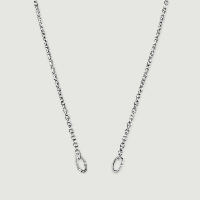 A fine silver chain descends in two strands with an oval ring at each end against a light gray background.