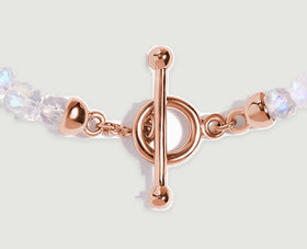 Rose gold links connect the round clasp and polished end caps to faceted pale moonstone beads.