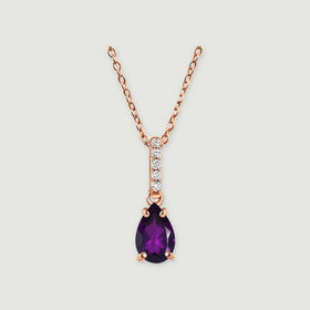 A rose gold vermeil necklace has a pear-shaped purple amethyst hanging beneath a vertical row of five clear stones on a light grey background.