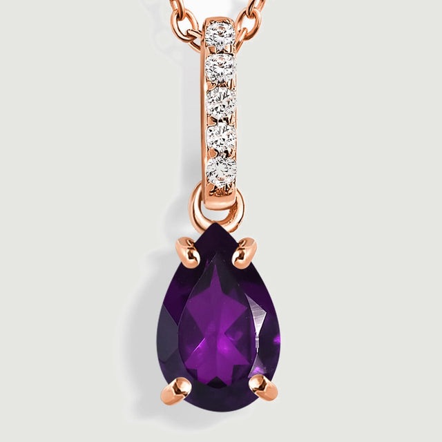 A close view shows rose gold prongs around a purple pear-shaped amethyst below five round clear stones.