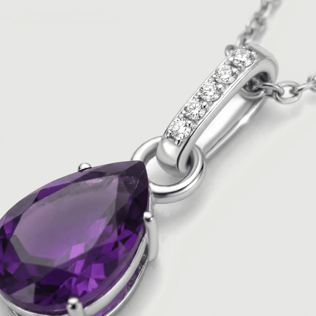 An angled close-up shows the silver connecting ring, five clear stones and the facets of a purple amethyst.