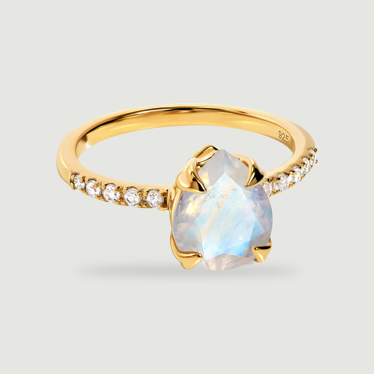 A yellow gold vermeil ring displays a faceted pear-shaped moonstone held by four prongs above a slender stone-set band.