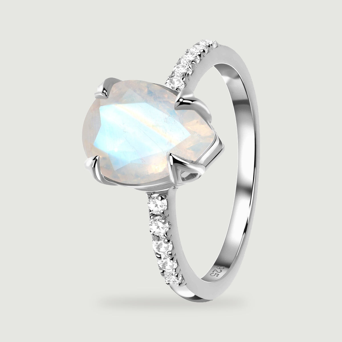 An angled view of the silver ring shows the moonstone facets, open setting and small clear stones on the shoulders.