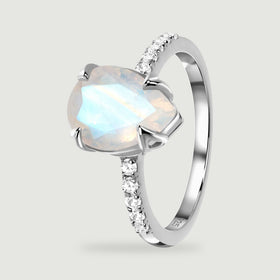 An angled view of the silver ring shows the moonstone facets, open setting and small clear stones on the shoulders.