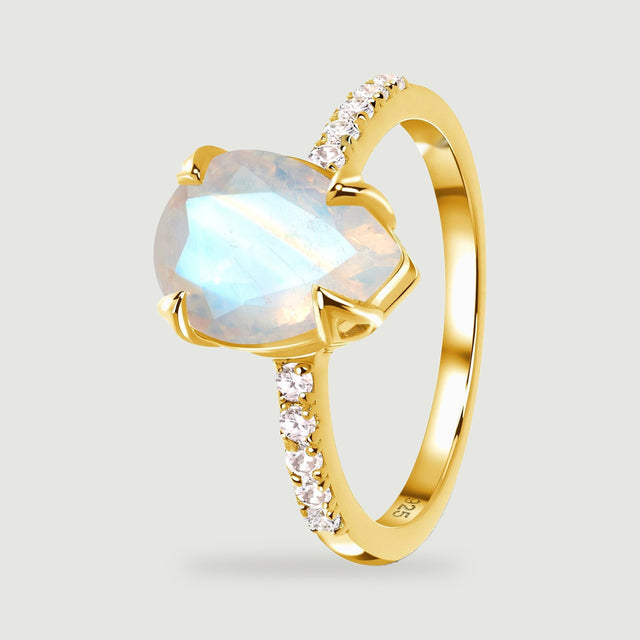 The yellow gold vermeil ring stands at an angle with its polished band and raised moonstone setting visible.