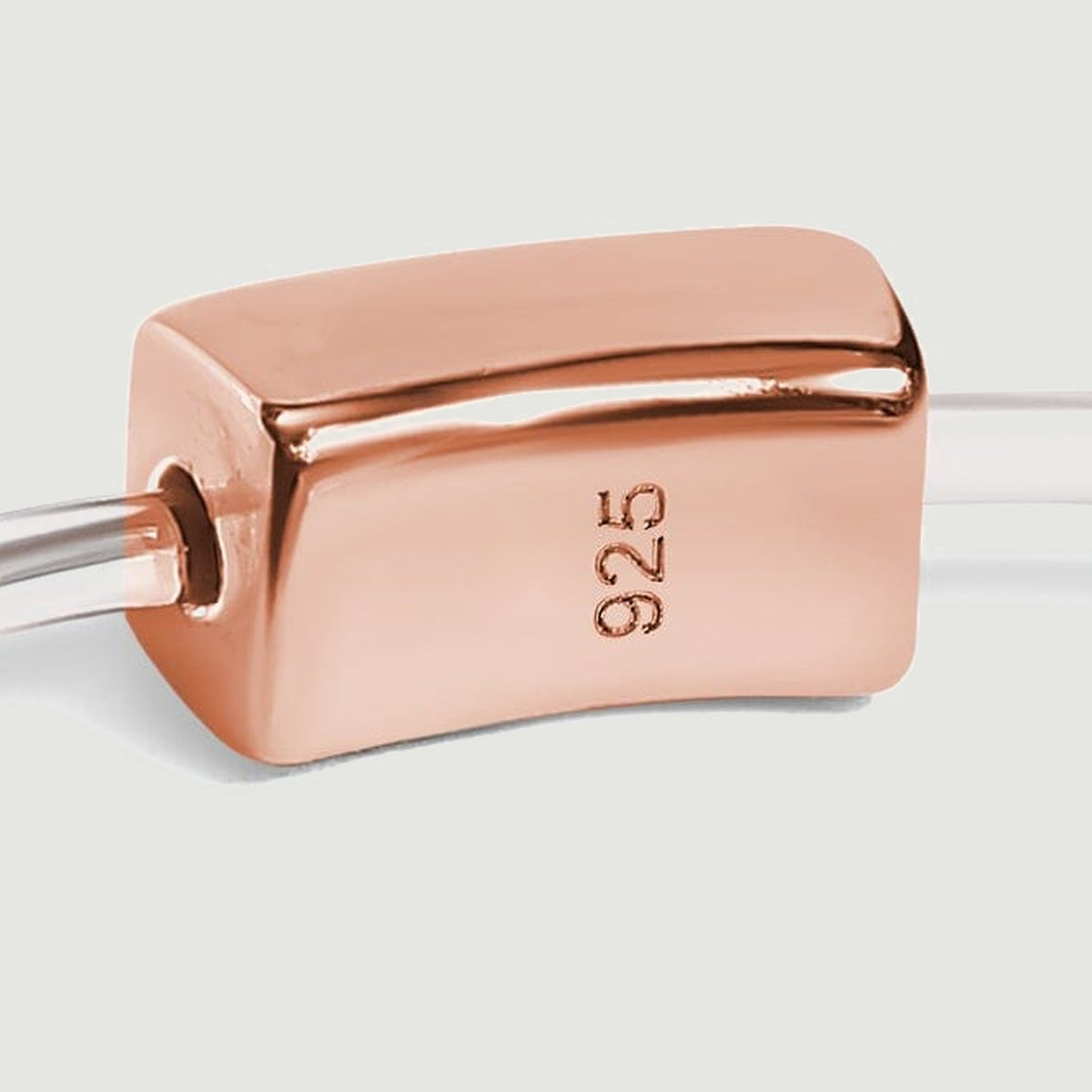 A rose gold rectangular slider marked 925 joins the slender pale ring band.