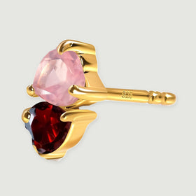 A side view reveals a yellow gold tone post and open settings behind two heart-shaped stones.