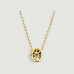 A yellow gold openwork oval locket with mixed gemstones and an oval-link chain is centered on a pale gray surface.