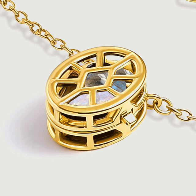 An angled yellow gold pendant reveals the depth of the oval cage beside a section of chain.