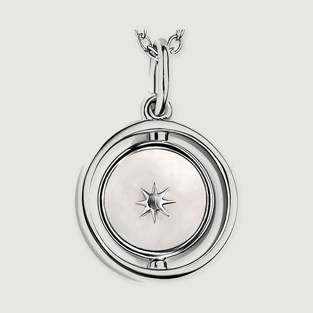 A close view of the silver pendant reveals a pale mother-of-pearl disc, an eight-point star and the open circular frame.