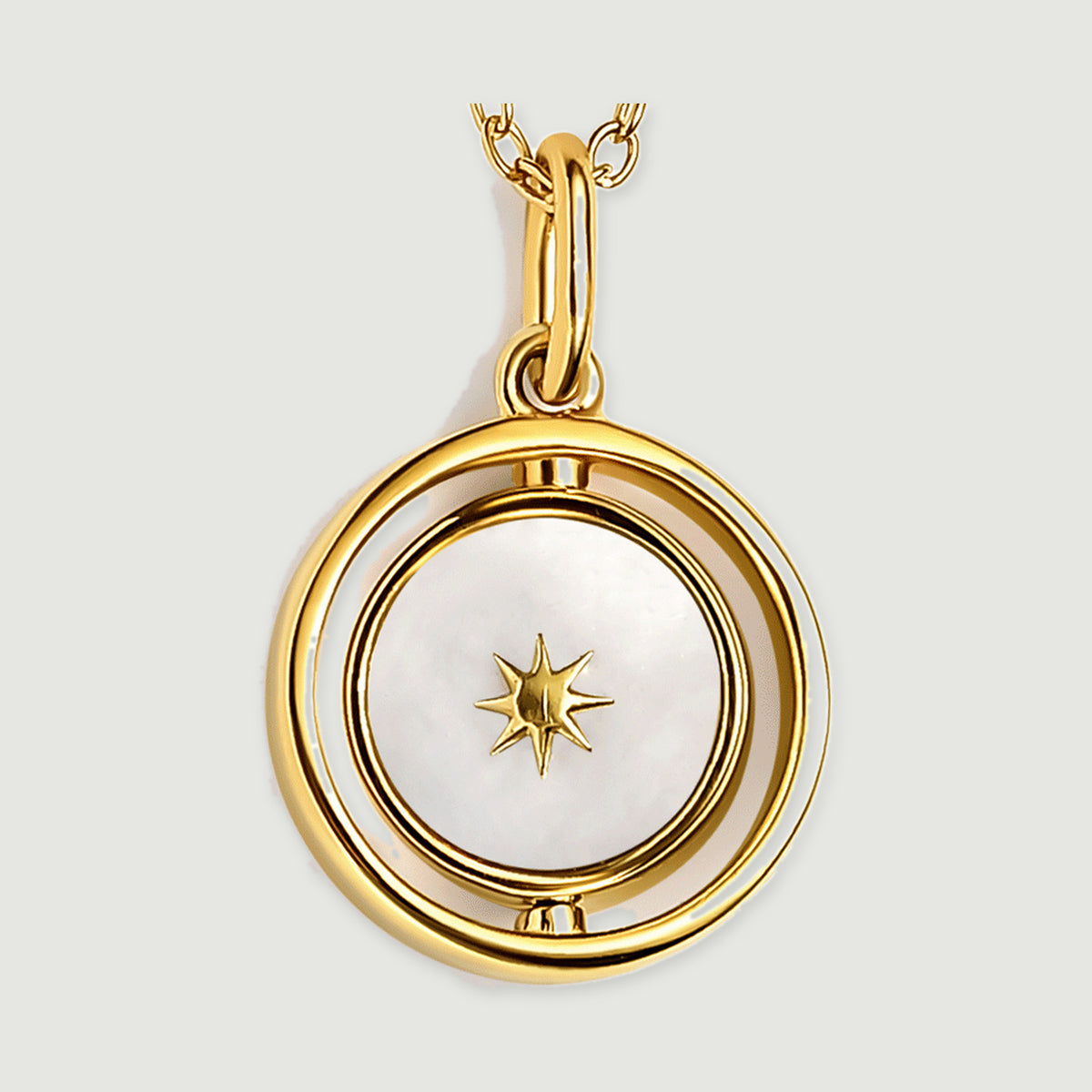 The yellow gold vermeil pendant is shown close up with a star on its pearly white face and a polished oval bail.