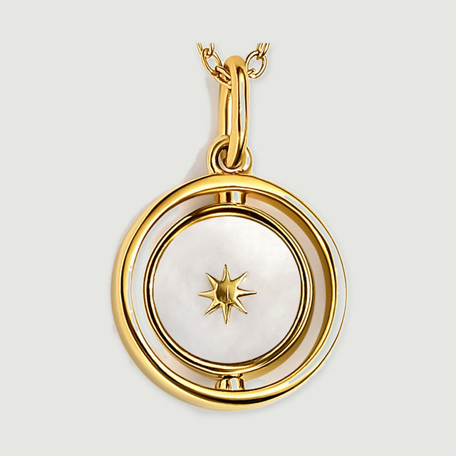 The yellow gold vermeil pendant is shown close up with a star on its pearly white face and a polished oval bail.