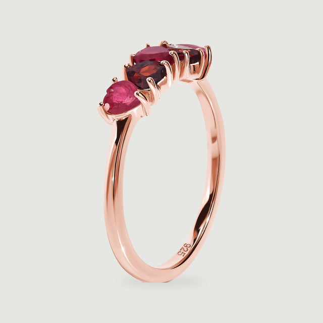 An upright rose gold ring shows the raised prong settings and curved band from the side.