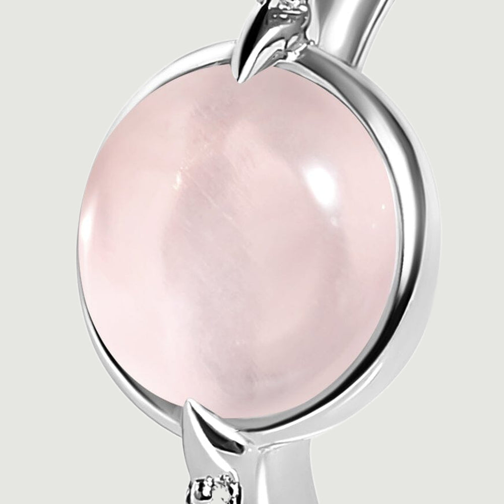 A close view shows the silver setting around the pink cabochon and a pointed prong beside a clear accent.