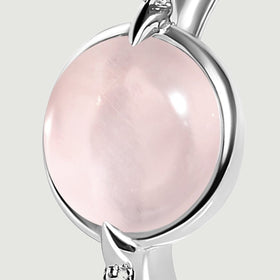 A close view shows the silver setting around the pink cabochon and a pointed prong beside a clear accent.