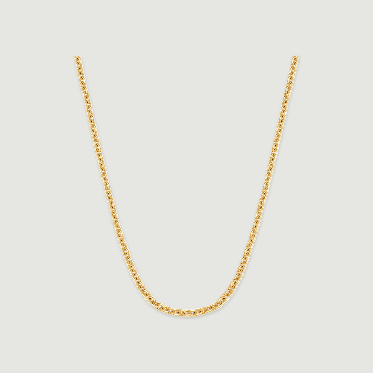 A yellow gold chain is centered in a U-shaped arrangement with a soft shadow.
