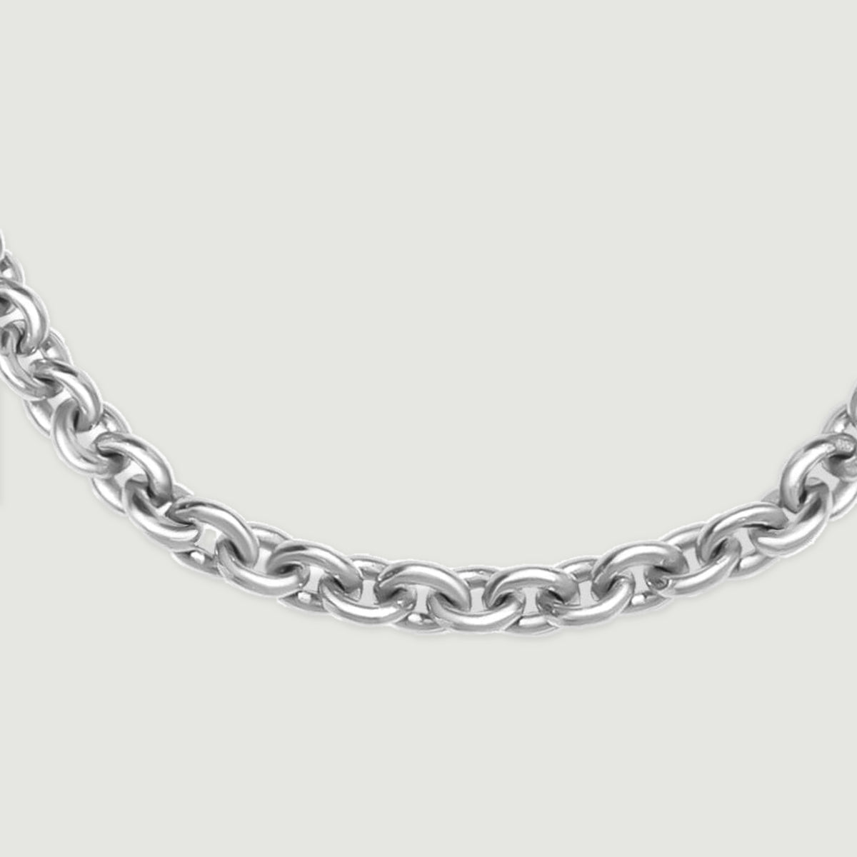 A close-up shows the rounded silver links along the lower curve of the chain.
