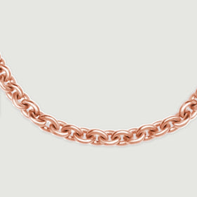 A curved row of rose gold chain links is shown at close range on light gray.