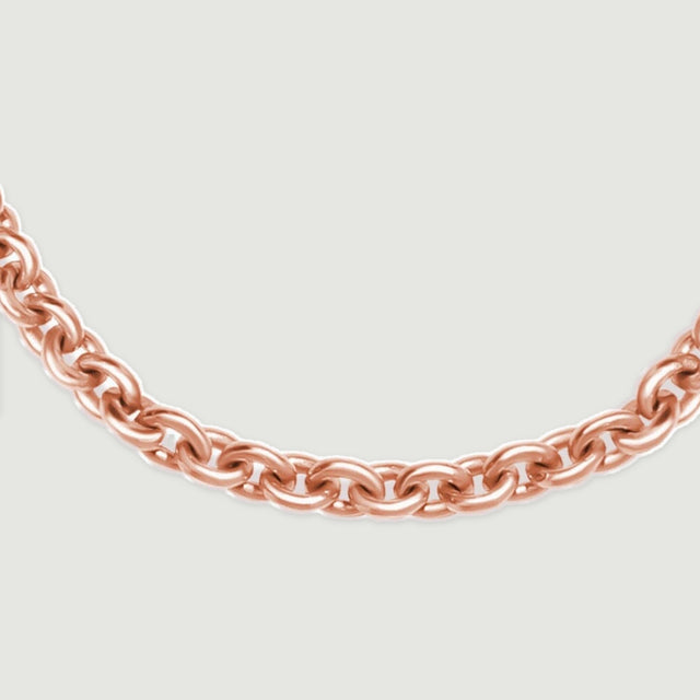 A curved row of rose gold chain links is shown at close range on light gray.