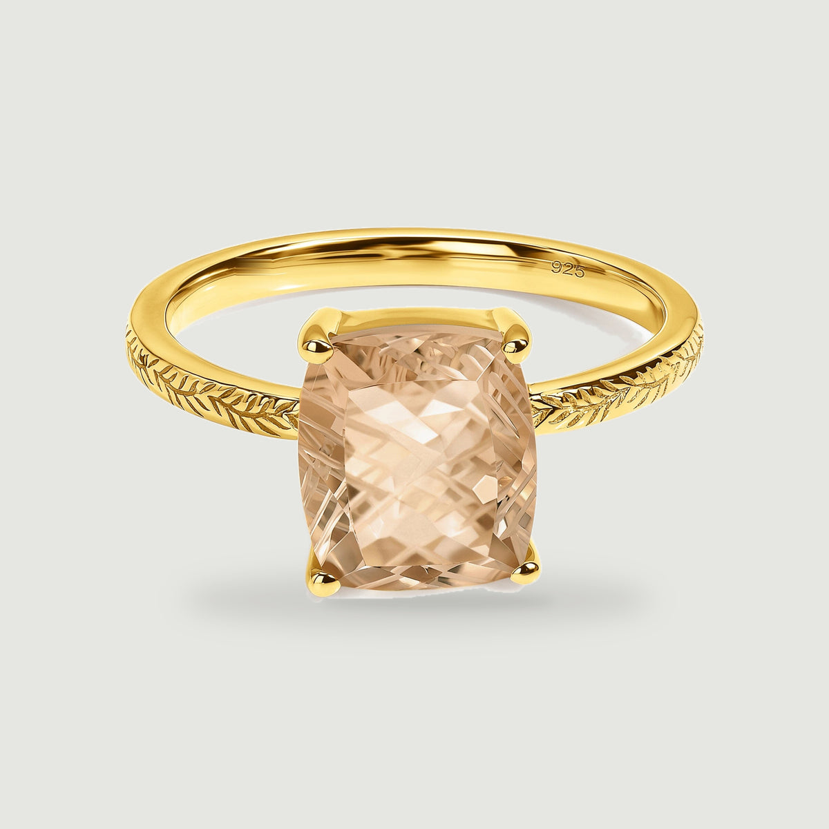 A yellow gold vermeil ring with a champagne-colored rectangular stone sits centered on a pale gray background.