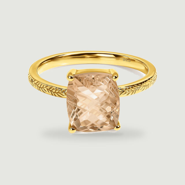A yellow gold vermeil ring with a champagne-colored rectangular stone sits centered on a pale gray background.