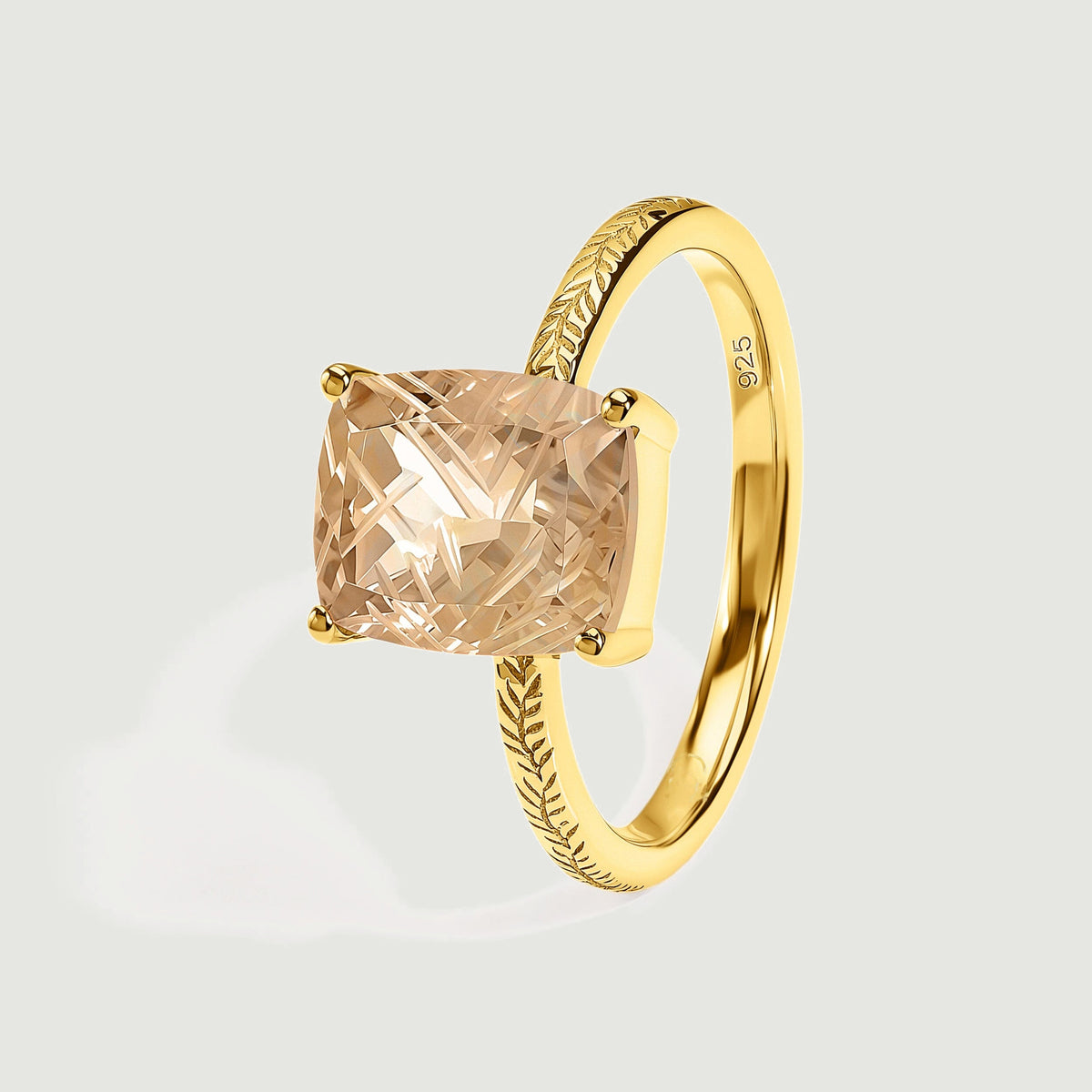 The yellow gold vermeil band curves behind a faceted champagne quartz in an angled view of the setting.