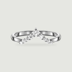 A polished silver chevron ring with round clear stones is centered on a pale gray background.