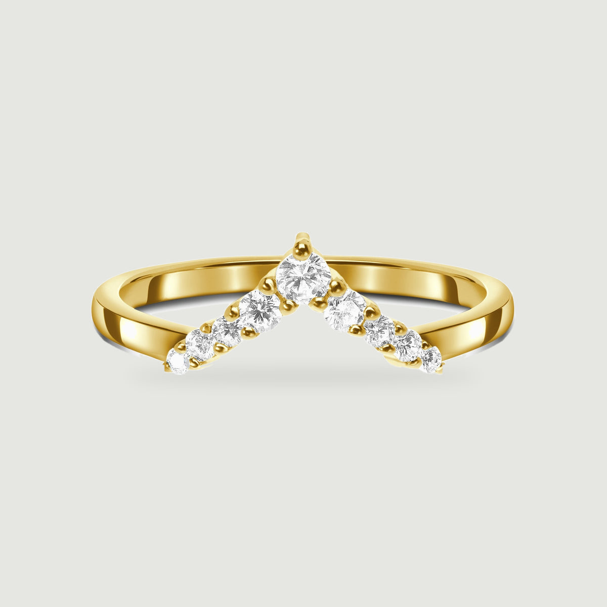 A yellow gold ring shows a pointed row of clear stones and a smooth curved shank.