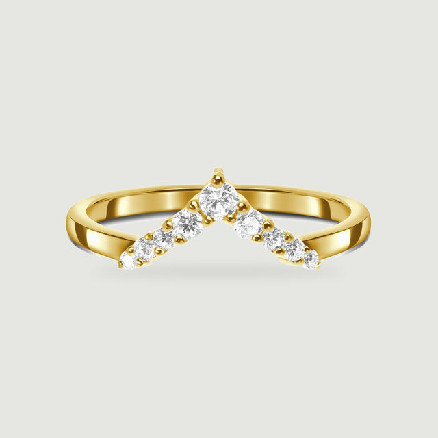 A yellow gold ring shows a pointed row of clear stones and a smooth curved shank.