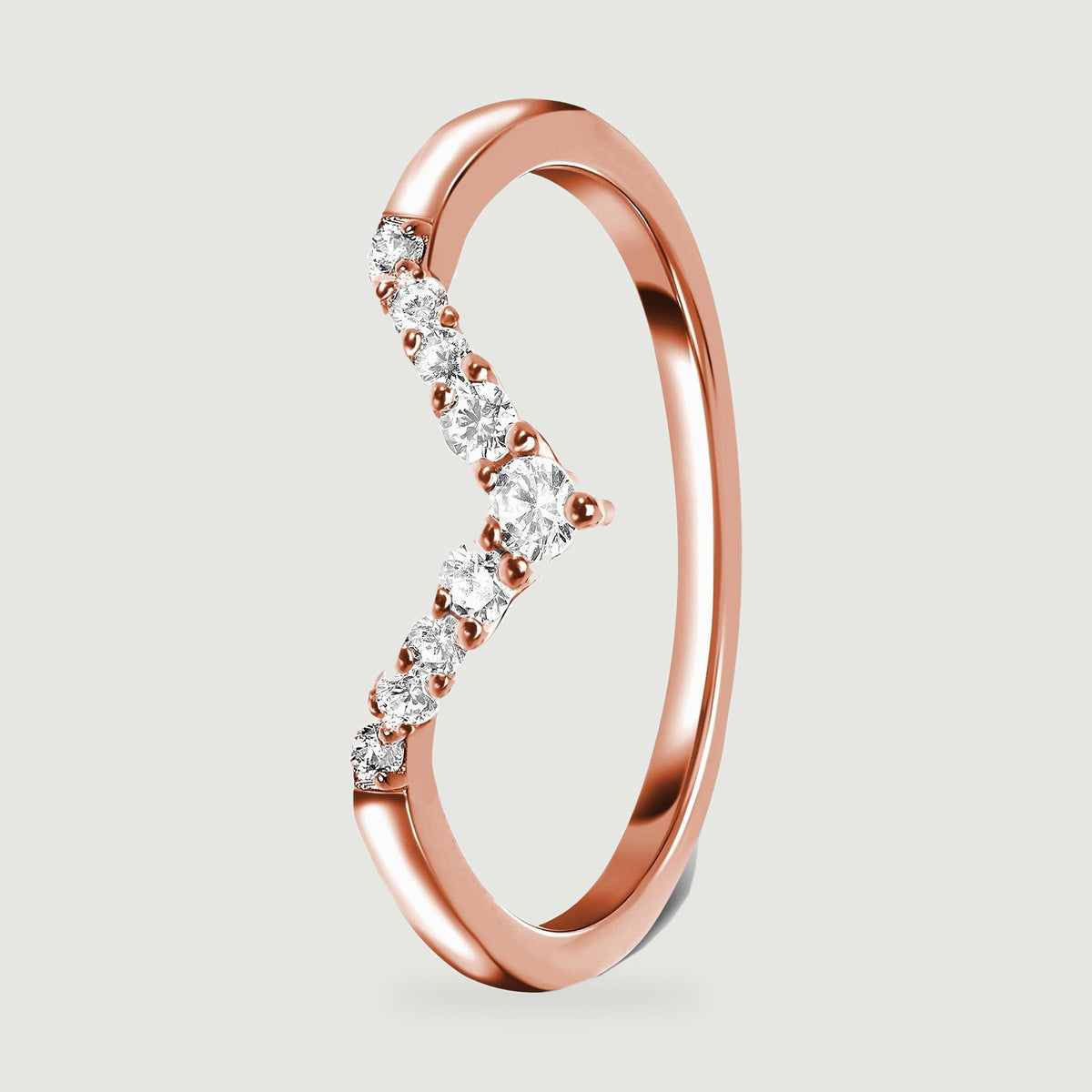 A side view of a rose gold ring shows its angular stone setting and polished inner surface.
