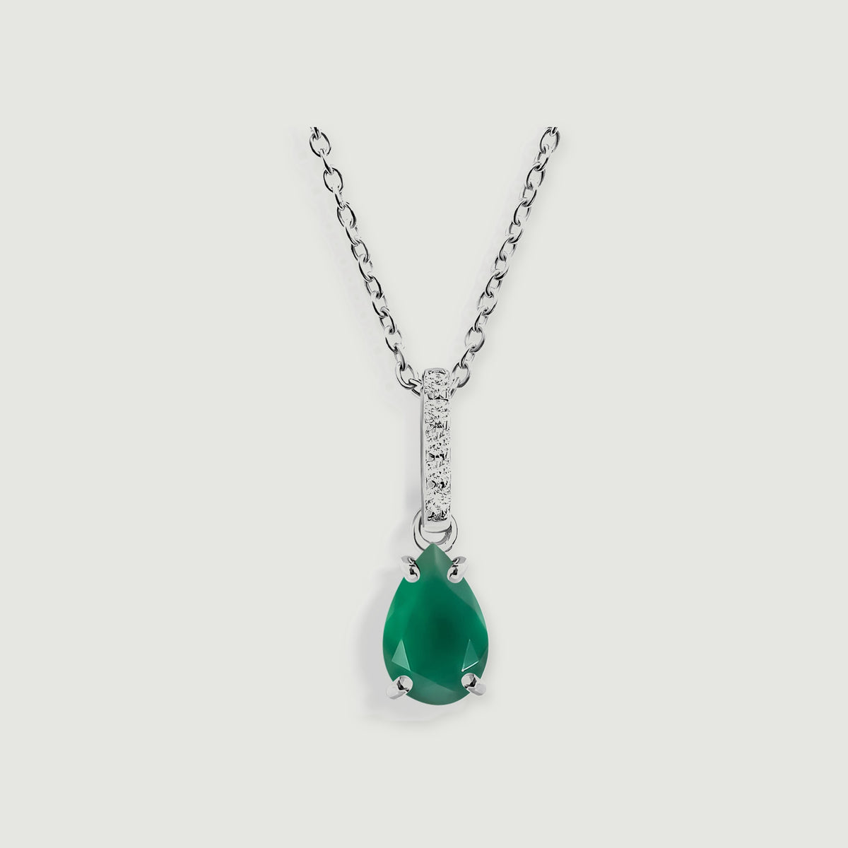 A silver necklace displays a faceted green drop beneath five round clear stones.