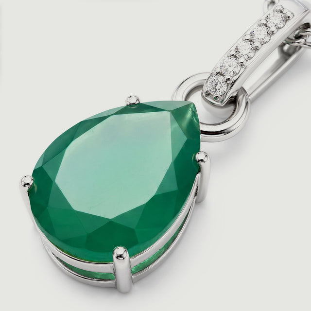 A close-up shows the green pear-shaped stone and the polished silver rim of its setting.