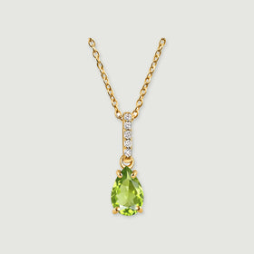 A pear-shaped green peridot hangs beneath five round white stones on a yellow gold chain against a light gray background.