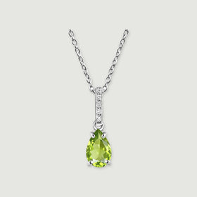 A silver chain meets a narrow white-stone bail above a faceted green pear pendant on a softly shadowed gray background.