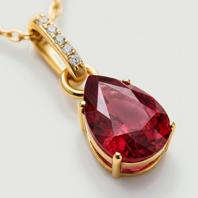 An angled close-up shows the red garnet facets, yellow gold prongs, and five clear stones along the curved bail.
