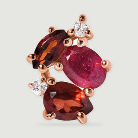 One rose gold vermeil stud is shown close up with rounded prongs and two small clear stones beside the red gemstone cluster.
