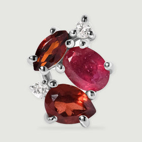 The front of a silver earring fills the frame with a pink oval stone, two red garnets and sparkling clear accents.